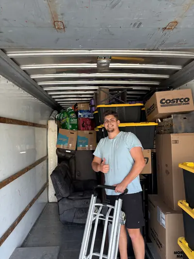 A mover with a hand truck inside a loaded moving truck