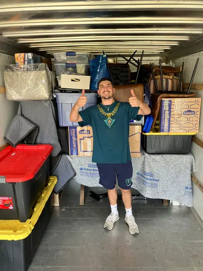 A mover giving two thumbs up in a fully loaded truck