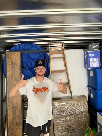 A mover giving two thumbs up in a loaded truck